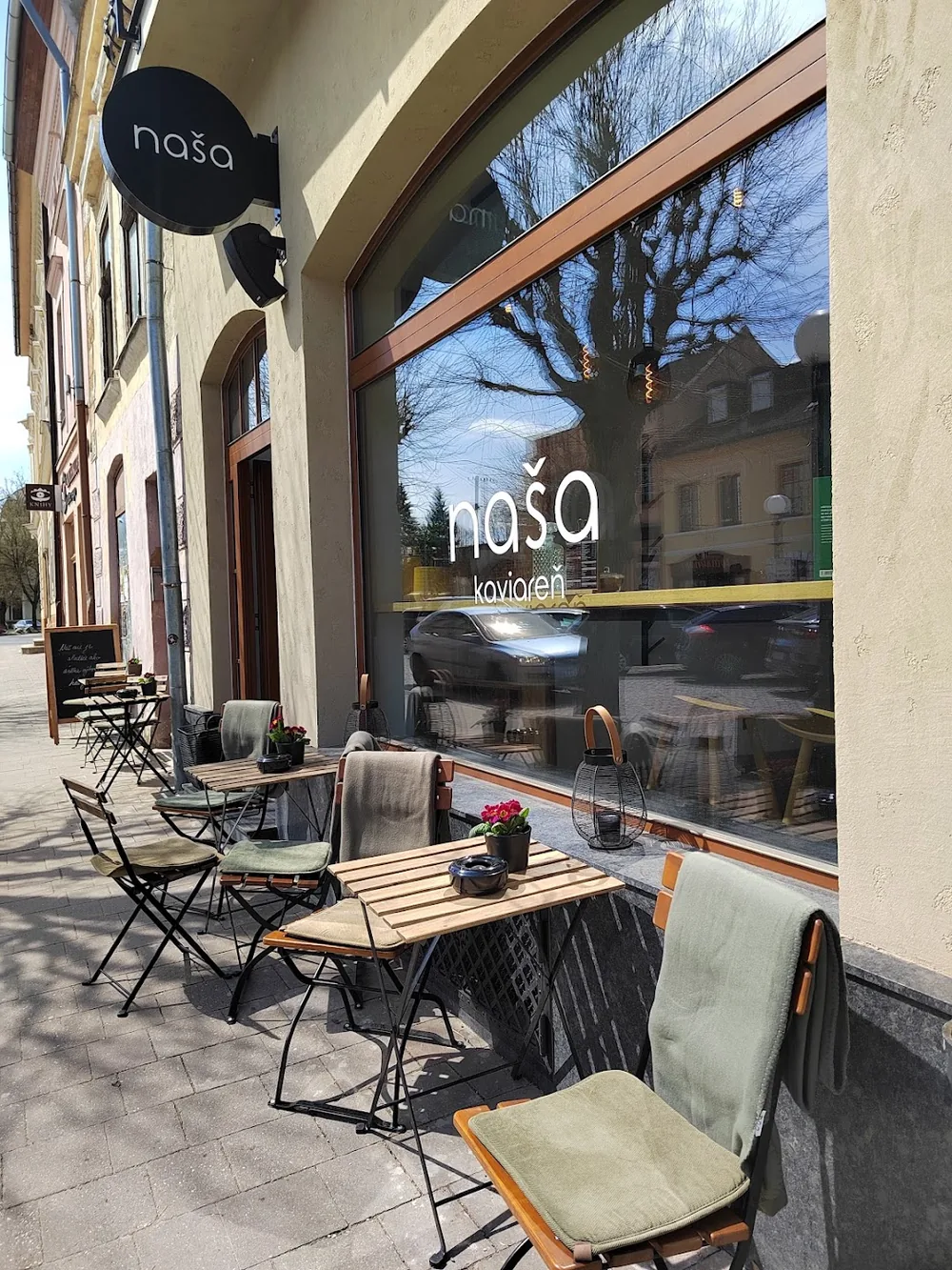 Prevádzka Naša kaviareň & bistro na Hviezdoslavovej v Kežmarku — čierna tabuľa naša a letná terasa